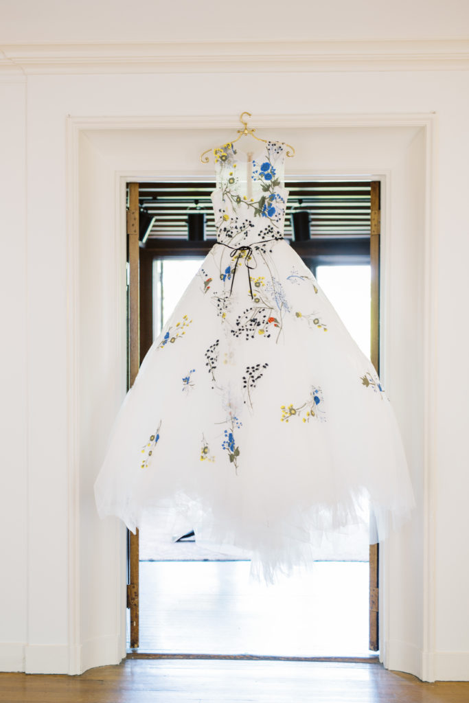 wedding dress hangs in the foyer of the willows Villanova mansion wedding venue