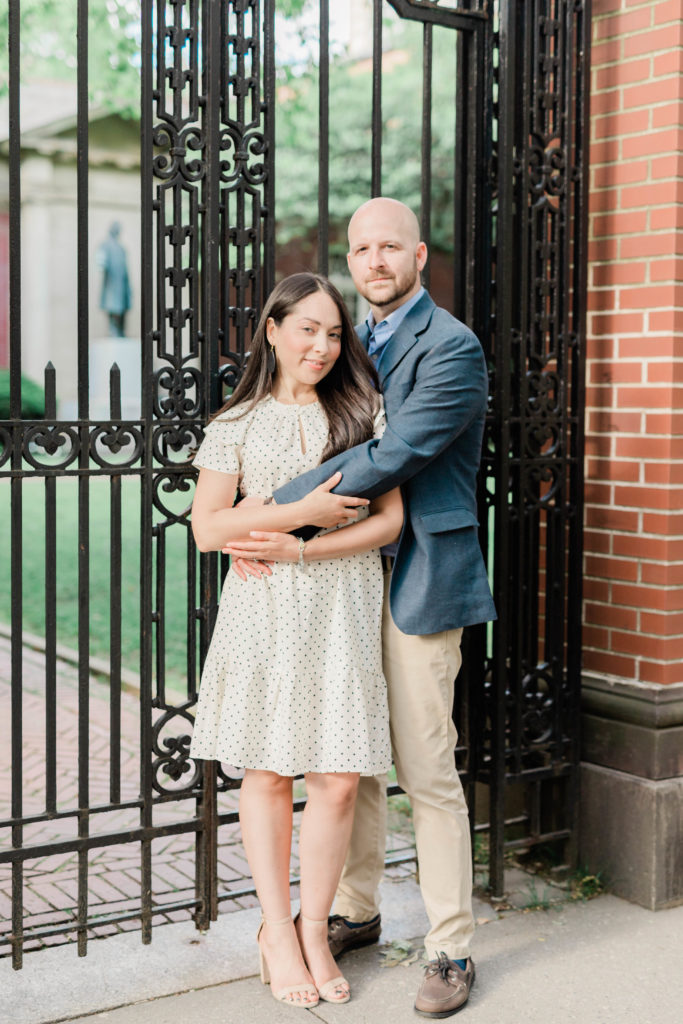 Couple embraces in front of gate in Brooklyn