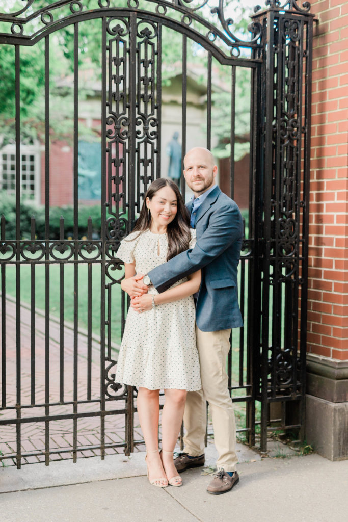 Couple embraces in front of gate in Brooklyn