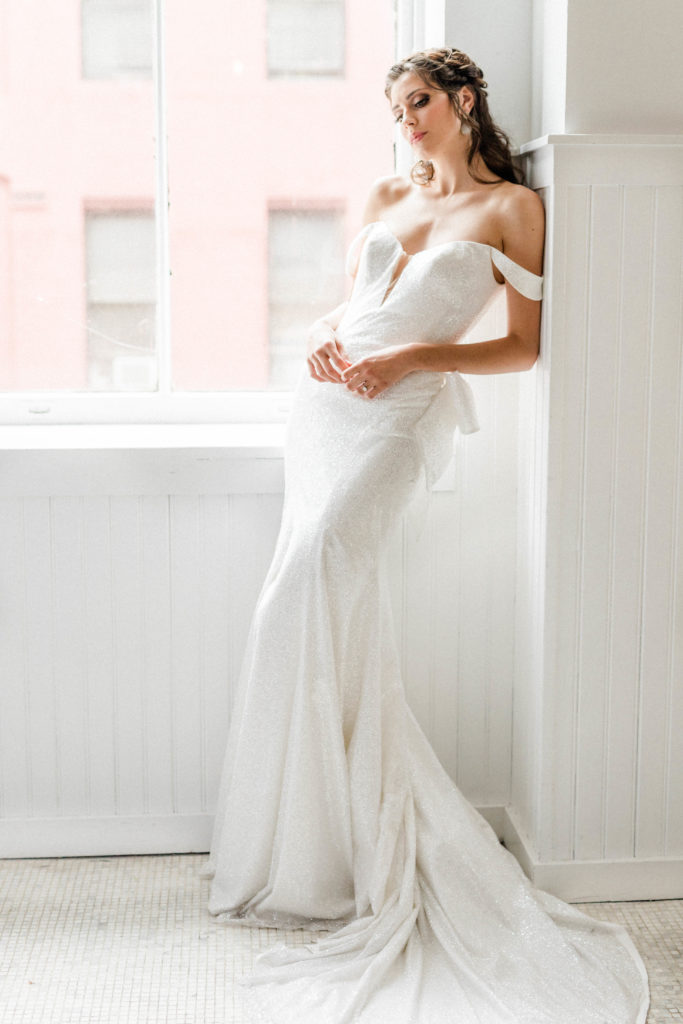 Bride looks longingly out of NYC loft window
