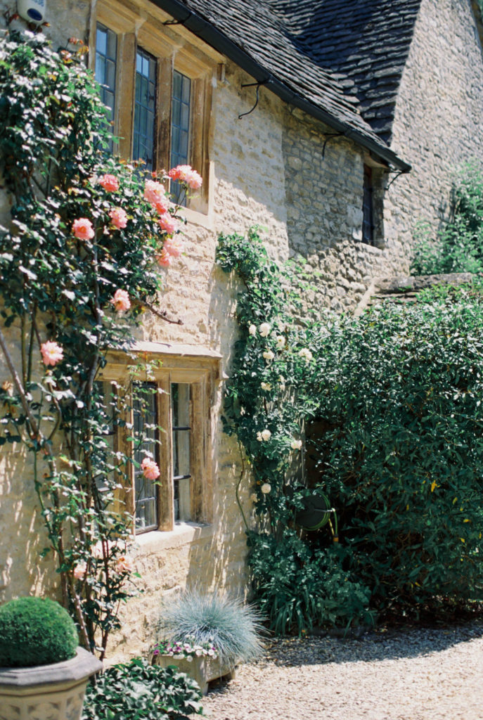 Pink climbing roses on a home in the village of Castle Combe, in England