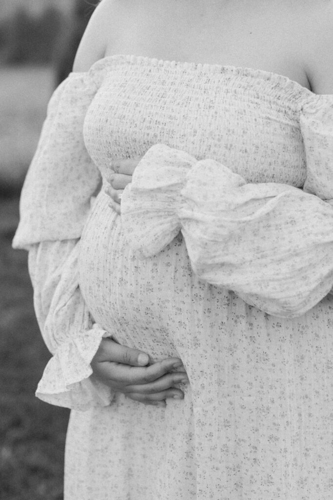 Woman tenderly holds her pregnant belly